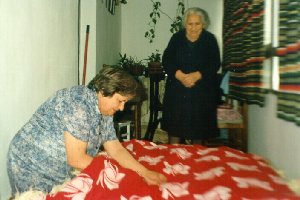 Juli cosiendo un colchón de lana bajo la atenta mirada de su madre